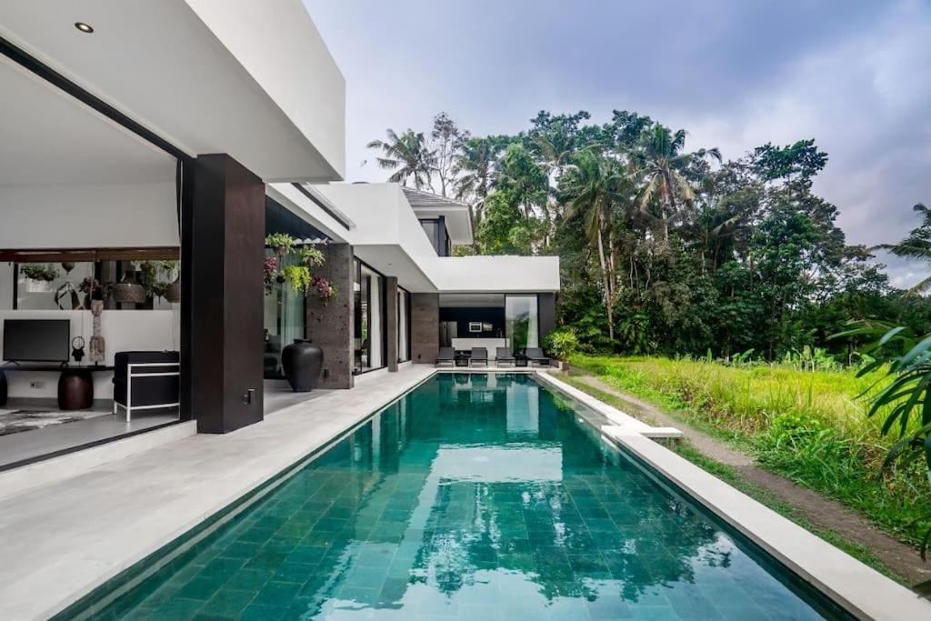 - une vue sur l'extérieur d'une maison avec une piscine dans l'établissement The R Villa Cereme - nature, quite, luxurious, à Tegalalang
