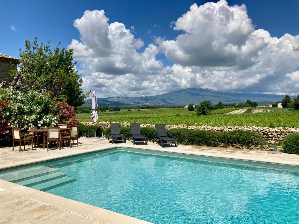 - une piscine avec des chaises et une table avec vue dans l'établissement Auberge de Mazan, à Mazan