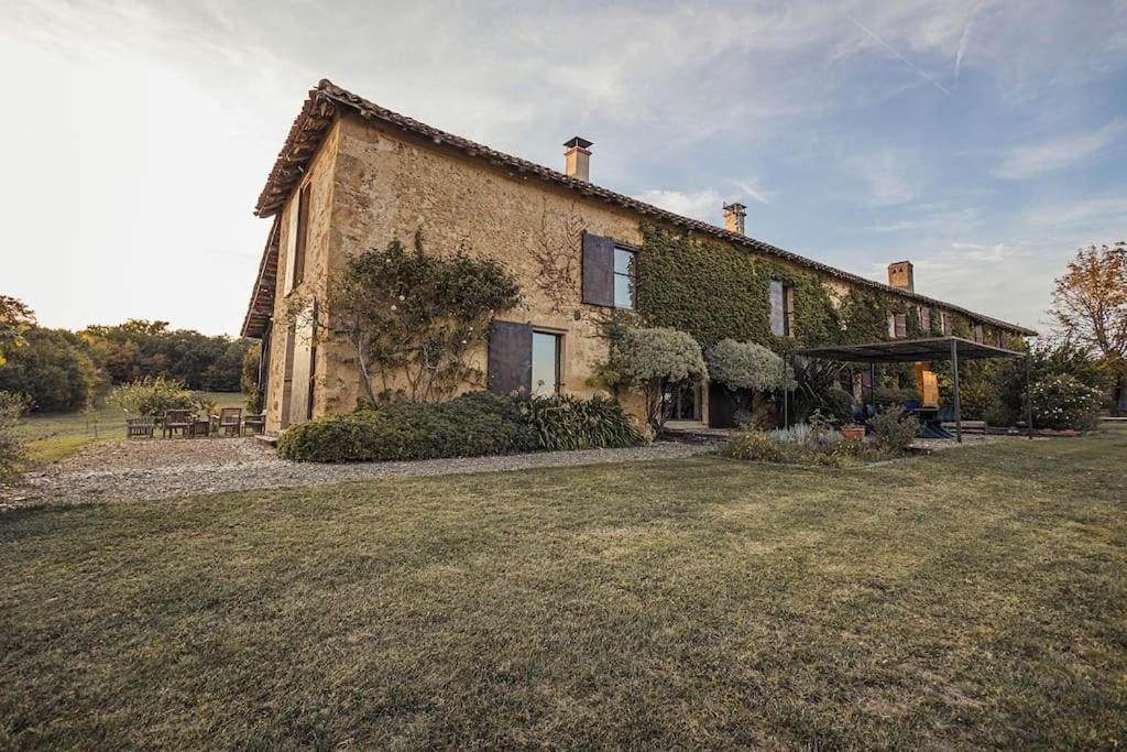 a large brick house with ivy on it at Maison d'architecte - piscine & court de padel privés + vue à 360° 