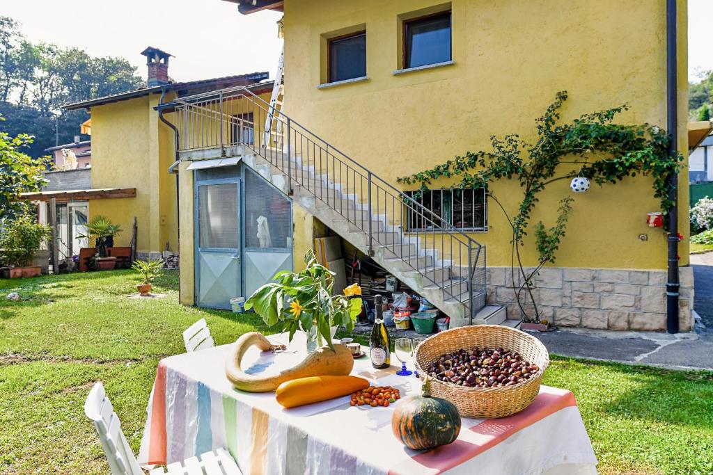 a table with fruits and vegetables on it in front of a house at Petit Jardin - Happy Rentals in Agno