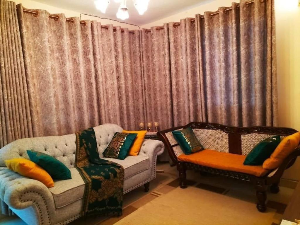 a living room with two chairs and a couch at Jantabase Homes kisumu in Kisumu