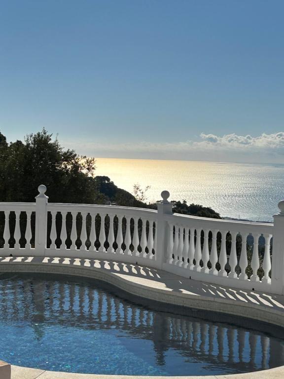 a white fence next to a pool with the water at Hearts & Home in Mijas