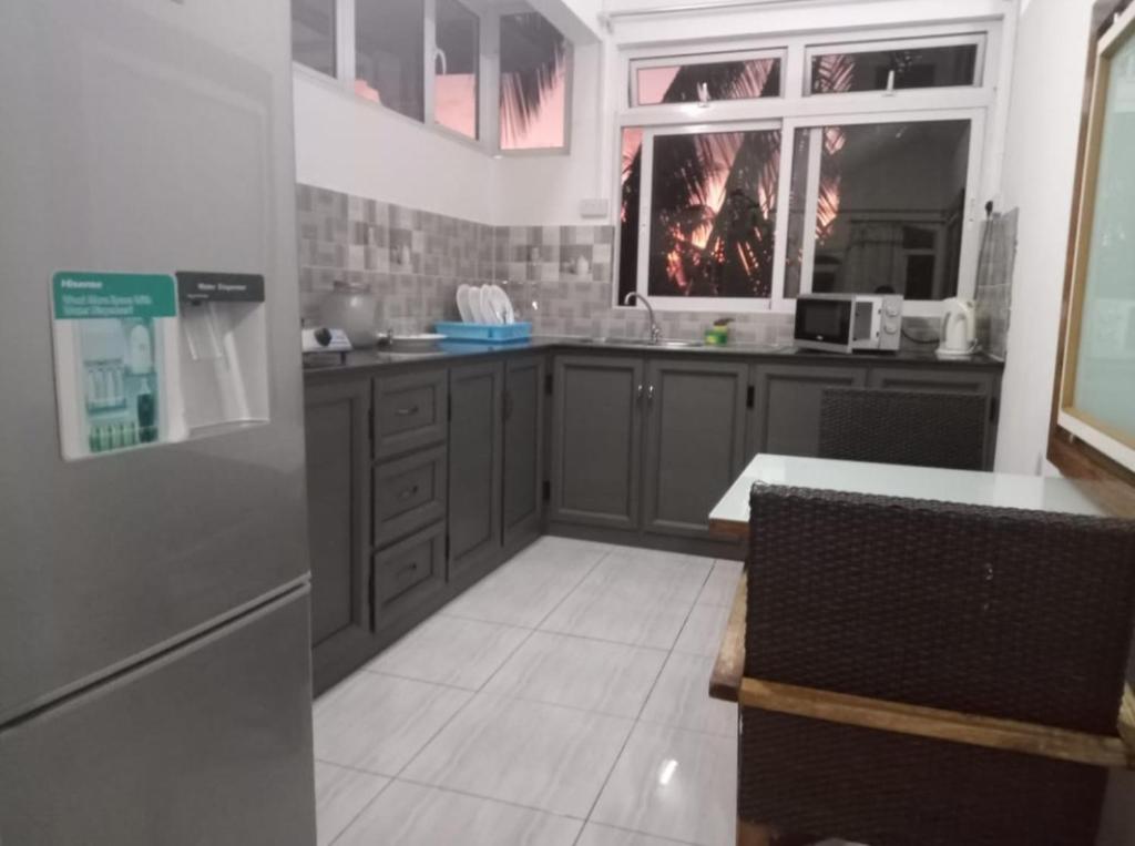 a kitchen with gray cabinets and a table and a window at Cheerful 1 bed vacation home with tours & facilities in La Gaulette