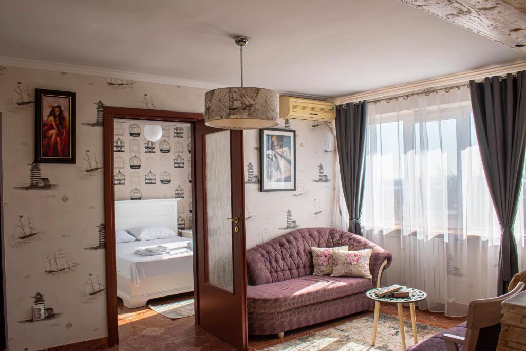a living room with a couch and a bed at Sunset by Old Town in Constanţa
