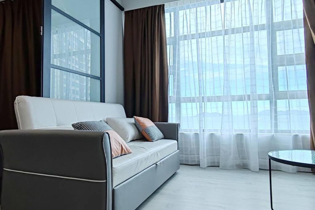 a living room with a couch and a large window at Nerv Homestay JQ T1 intermediate- seaview in Kota Kinabalu