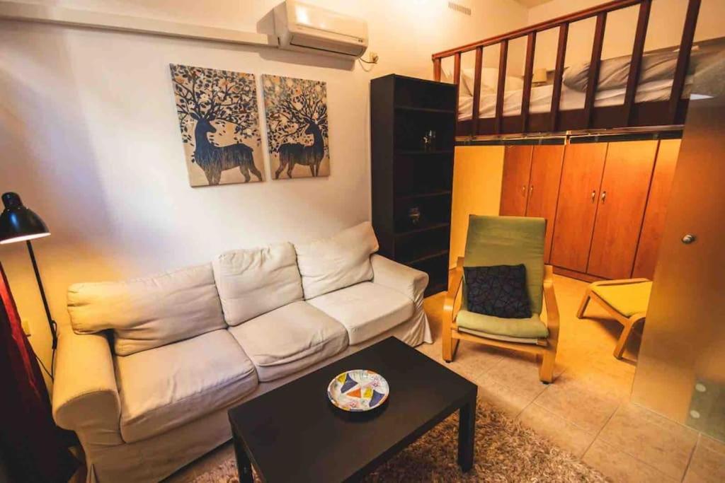 ein Wohnzimmer mit einer weißen Couch und einem Stuhl in der Unterkunft Apartment at N Kosmos in Athen