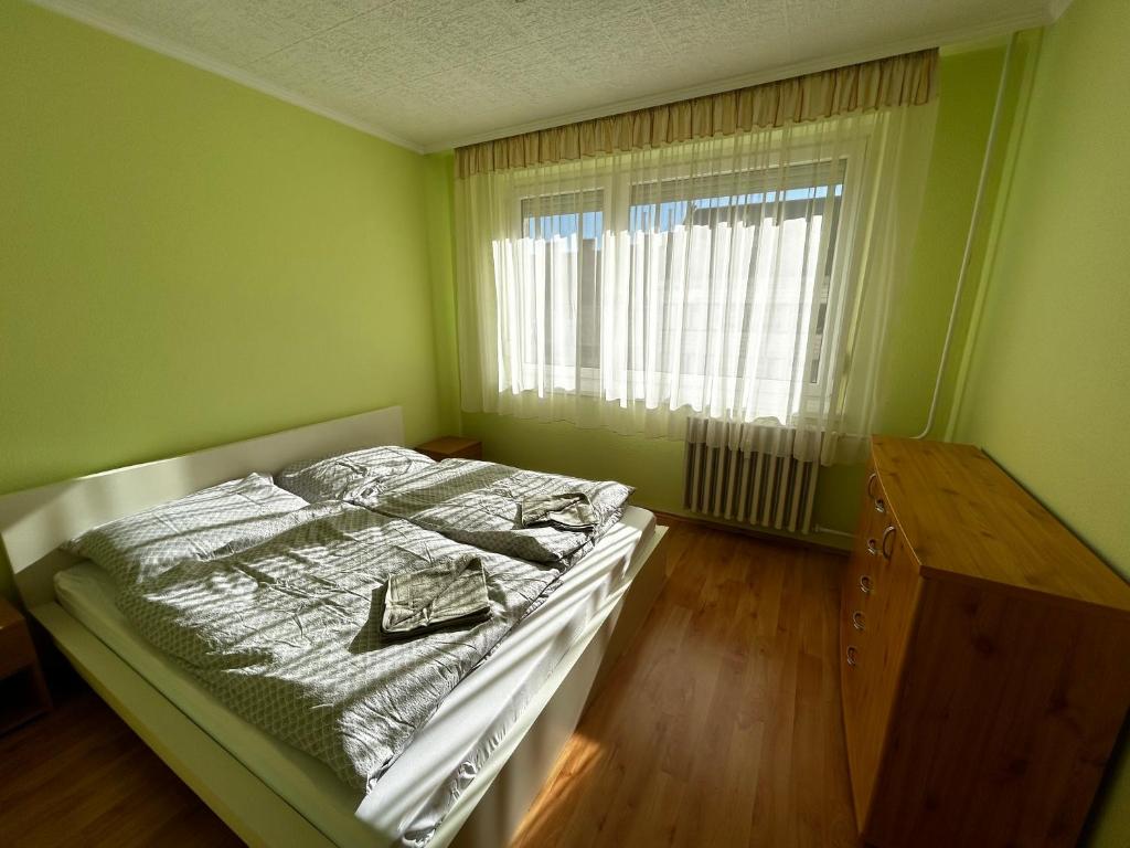 a small bedroom with a bed and a window at Backstage in Győr
