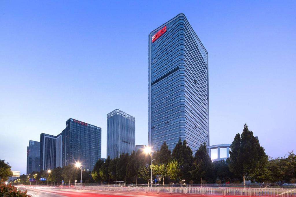 a tall building with a sign on it in a city at Hilton Garden Inn Zibo Zhangdian in Zibo
