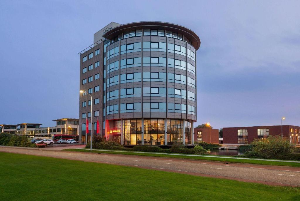 a tall glass building with a round top at Amedia Amsterdam Airport, Trademark Collection by Wyndham - Free Parking in Schiphol