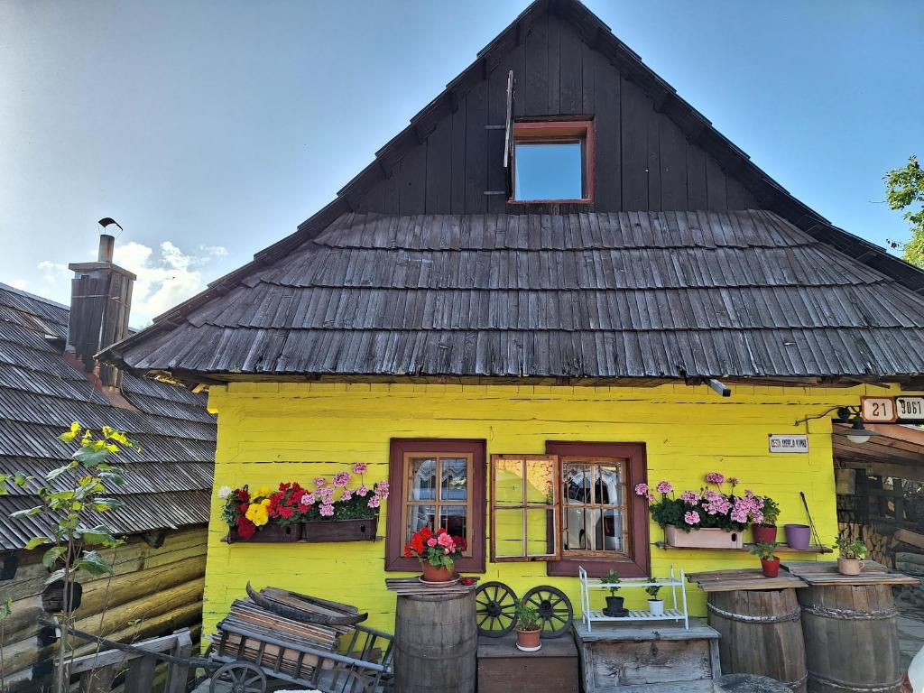 una casa amarilla con techo negro en Chata Vlkolínec, en Ružomberok