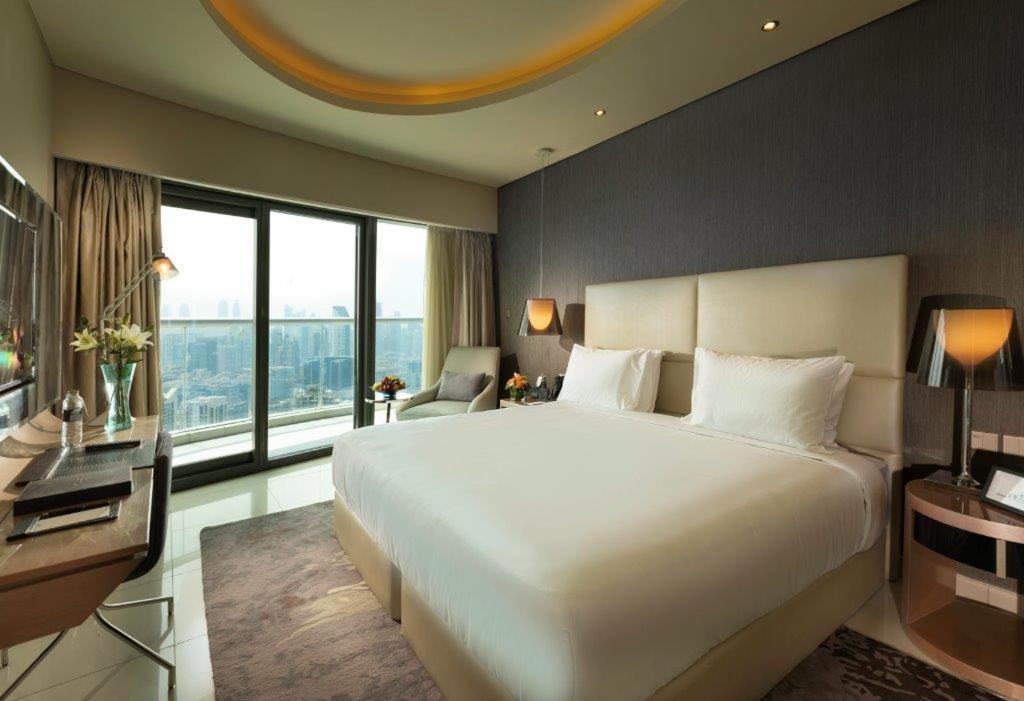 a bedroom with a large white bed and a large window at PARAMOUNT Hots & residential property in Dubai