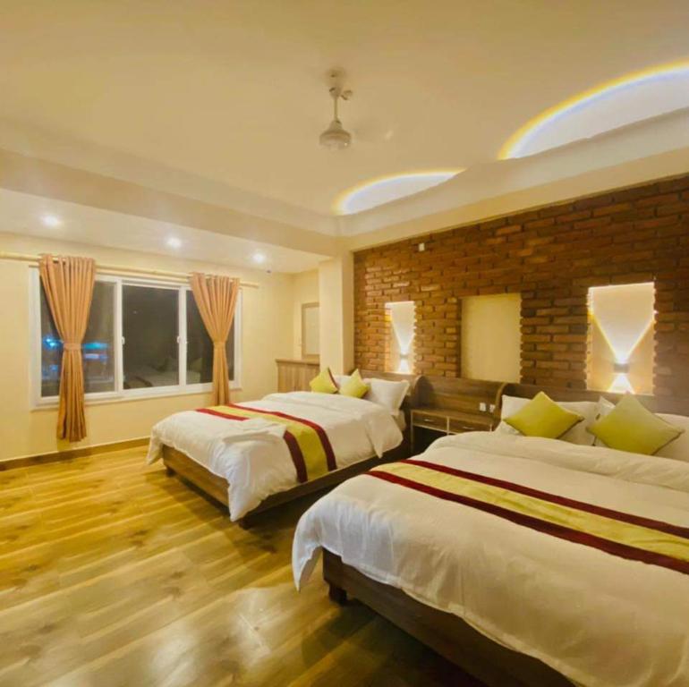 - une chambre avec 2 lits et un mur en briques dans l'établissement Hotel Highway 75, à Benighāt