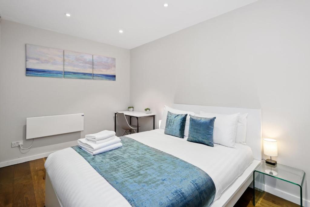 a bedroom with a white bed with a blue blanket at Spacious 1 bedroom flat in London