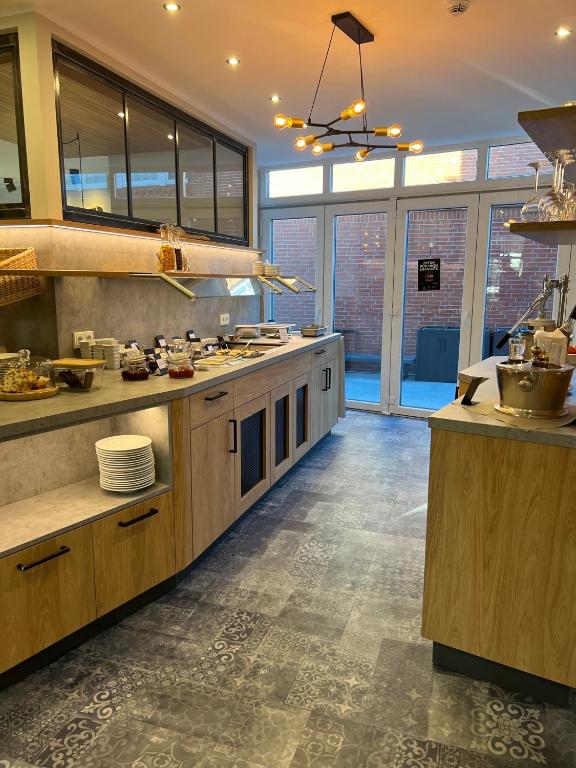 a large kitchen with wooden cabinets and counters at Deichhotel Rose in Juist