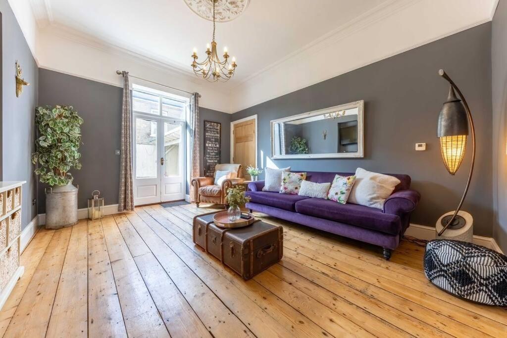 a living room with a purple couch and a table at 58D Earlham Road in Norwich