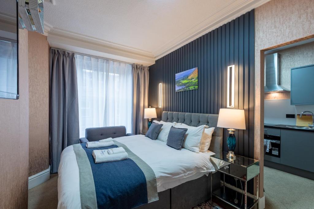 Un dormitorio con una cama grande y una ventana en THE AMBLESIDE APARTMENTS - Self catering with private kitchen - Best for Location, en Ambleside