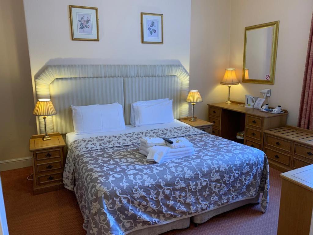 a hotel room with a bed with two towels on it at The Redcliffe Hotel in Scarborough