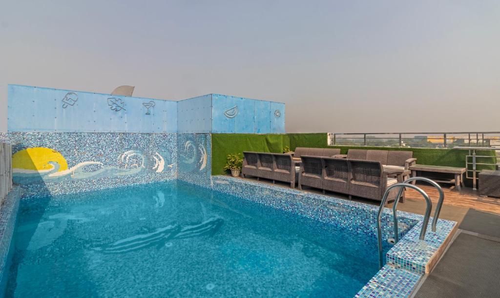 a large swimming pool with chairs and a swimming pool at Treebo Trend The Royal Taj 3900 m from Taj Mahal Agra in Agra