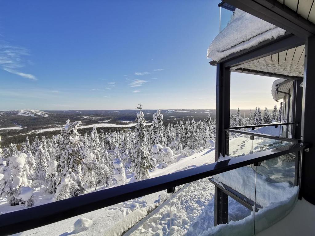 a room with a view of a snow covered forest at Näköalahuoneisto 324 in Syöte