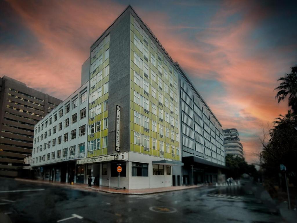 a large building on a street with a cloudy sky at Parliament Hotel in Cape Town