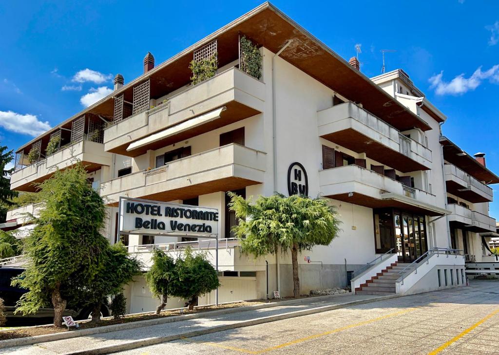 a building with a sign for a hotel in a parking lot at Hotel Bella Venezia in Latisana