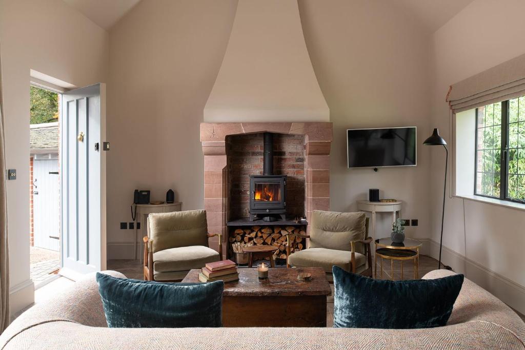 a living room with a fireplace and a couch at Blacksmith's Cottage in Nantwich