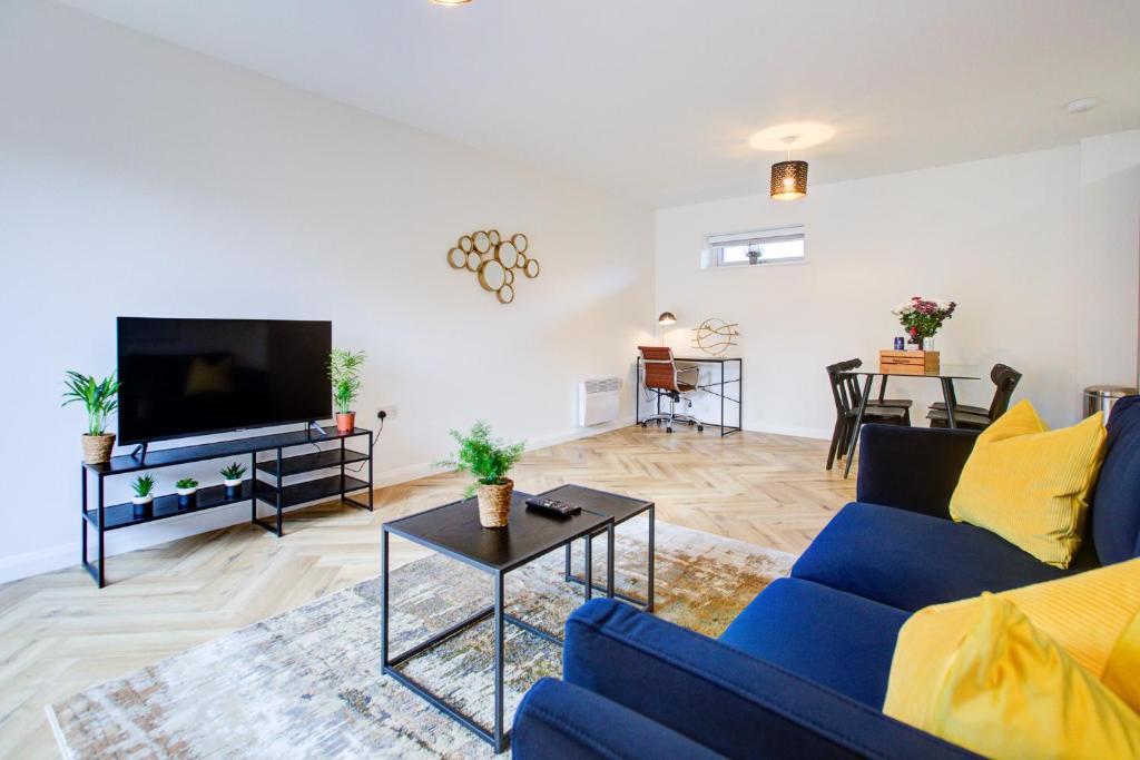 a living room with a blue couch and a tv at Hybrid Resi - Mitcham close to Tooting and Wimbledon in Mitcham
