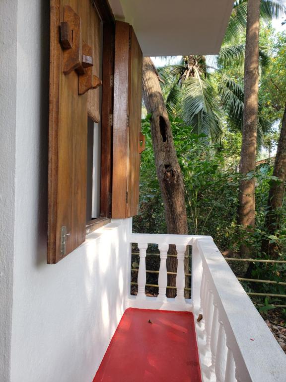 a stairway with a red carpet and a window at Laxmi Happy Home in Querim Goa in Querim