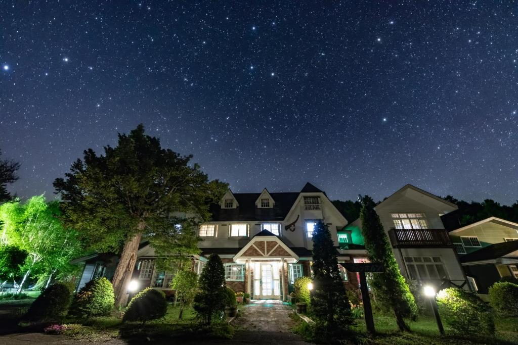 Una casa de noche con las estrellas en el cielo en 乗鞍高原温泉 アルプホルン en Matsumoto