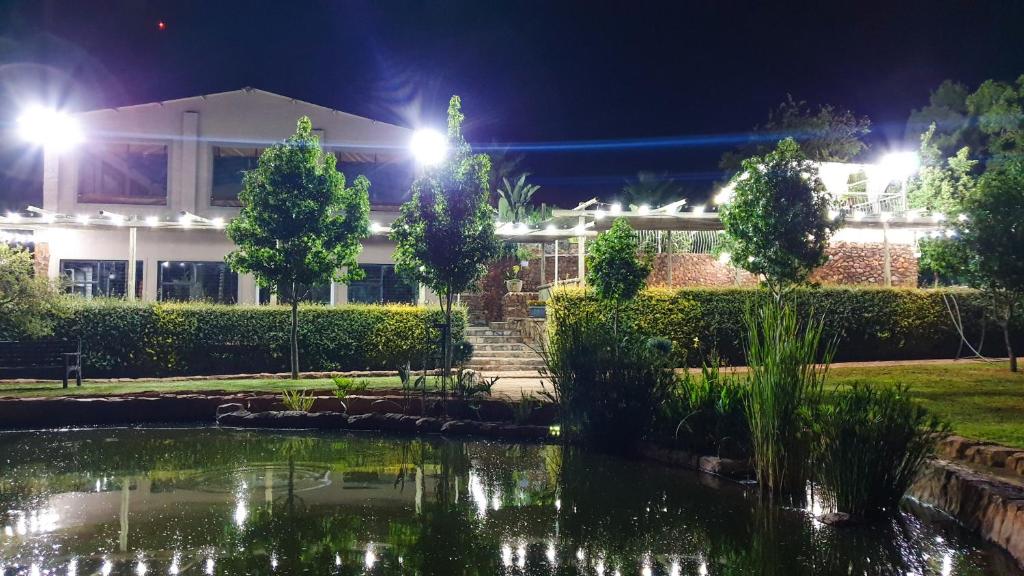 a pond in front of a building at night at Koi Inn in Hartbeespoort