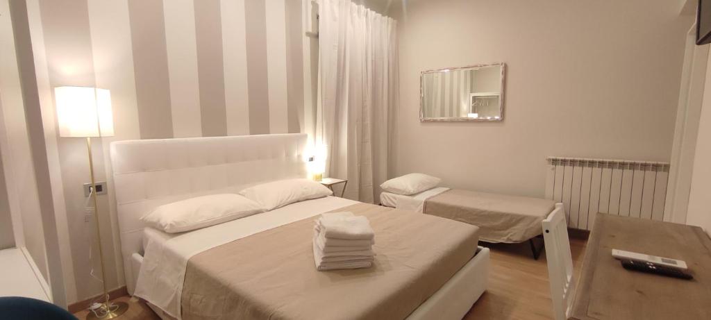 a small white bedroom with a bed and a table at Portonaccio suite - Stazione Tiburtina - Università - Metro B in Rome