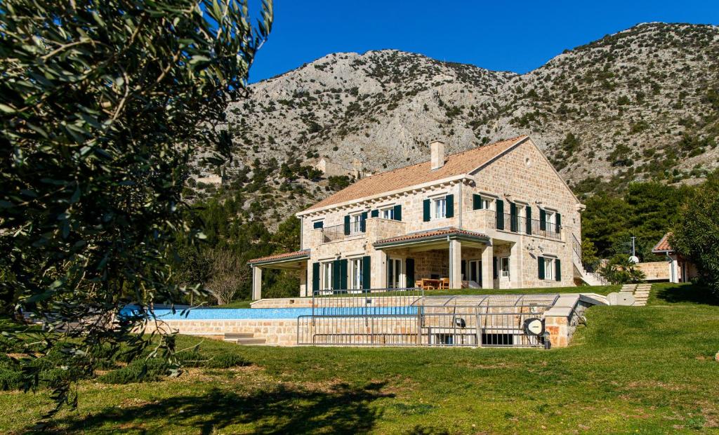 una casa con piscina frente a una montaña en Elegant Brac Villa 4 Bedrooms Villa Beachfront Oasis Stunning Sea Views and Walking Distance to Beach Murvica en Murvica
