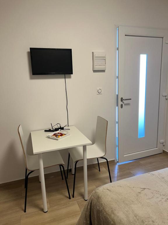 a room with a table and two chairs and a television at Maison letiluca in Hésingue