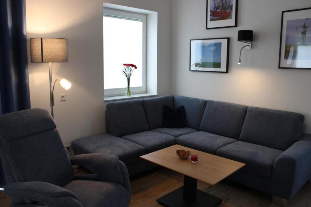a living room with a blue couch and a table at Am Kutterhafen 3 - PIER 3 in Fedderwardersiel