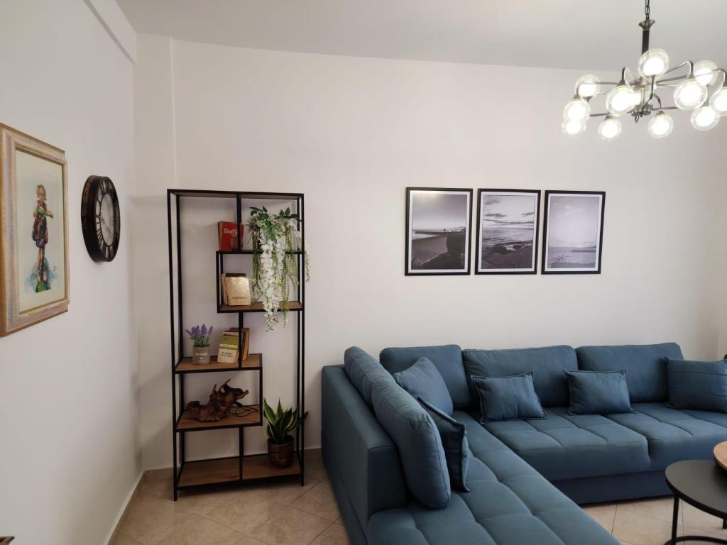 een woonkamer met een blauwe bank in een kamer bij Durres Center in Durrës