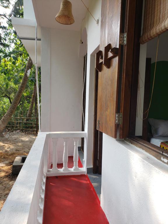 a red carpet on the side of a house with a window at Laxmi Happy Home in Querim Goa in Querim