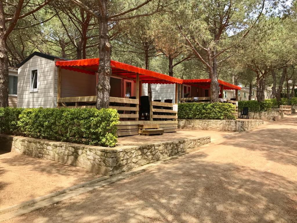 une maison avec un toit rouge dans un parc dans l'établissement Greenchalets Costa Brava Palamos, à Palamós