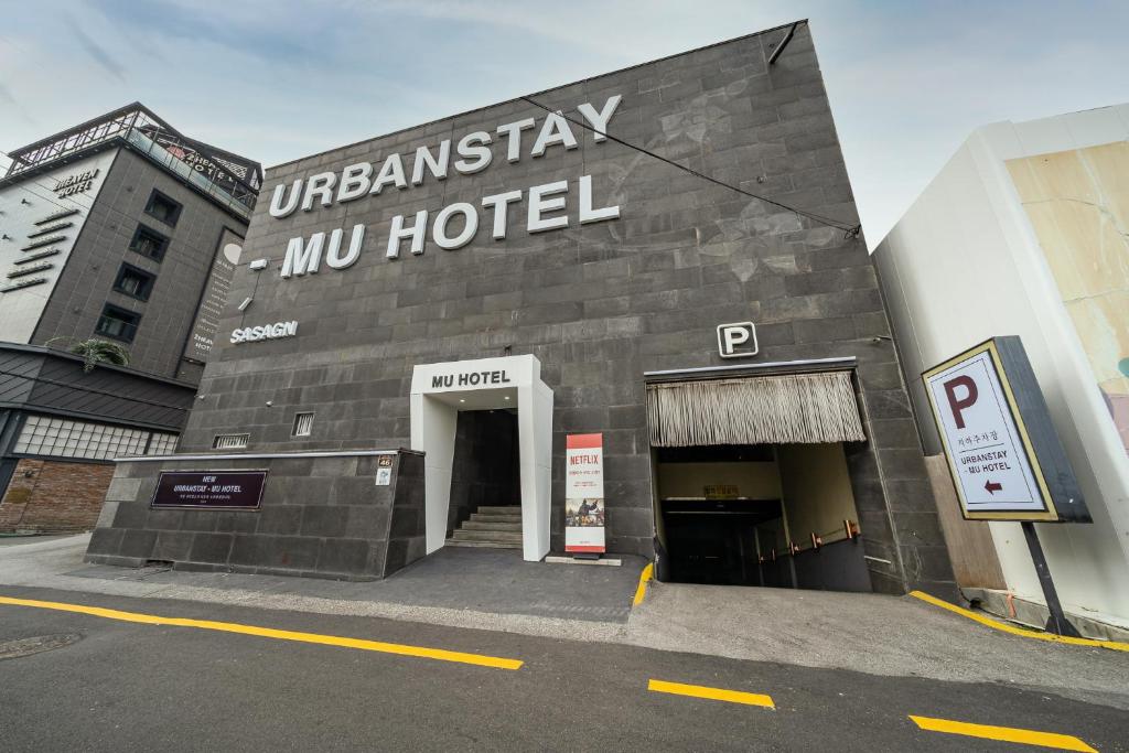 ein Gebäude mit einem Schild auf der Seite des Hotels in der Unterkunft MU HOTEL in Busan