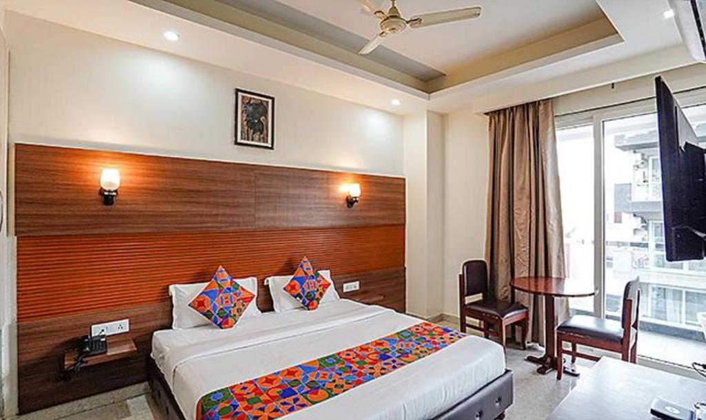 a hotel room with a large bed and a desk at FabHotel Grace Inn in Gurgaon
