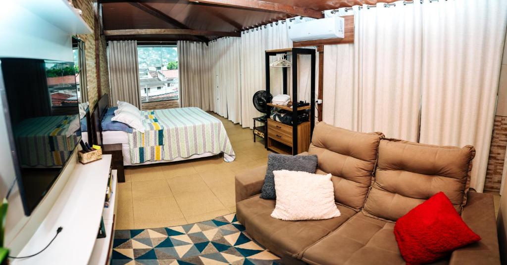 sala de estar con sofá y dormitorio en APTO - Espaço Único Vix, en Vitória