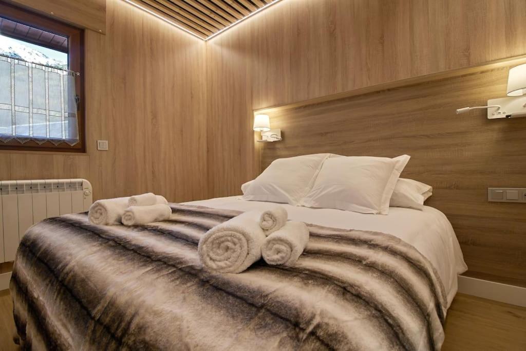 een slaapkamer met een groot bed en handdoeken bij Apartamento Hartza in Vielha