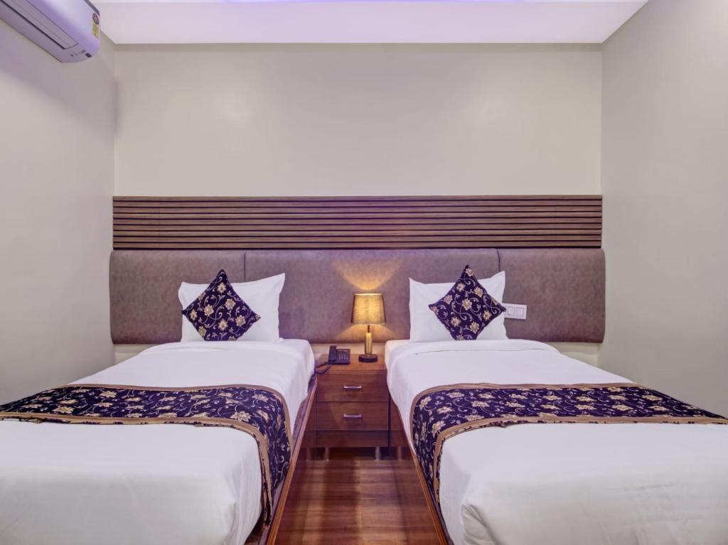 a hotel room with two beds and a lamp at THE SUPERB HOTEL PVT LTD in Hyderabad