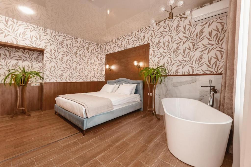 1 dormitorio con cama y bañera en Park Hotel Tskaltubo - Balneo Resort, en Tskaltubo
