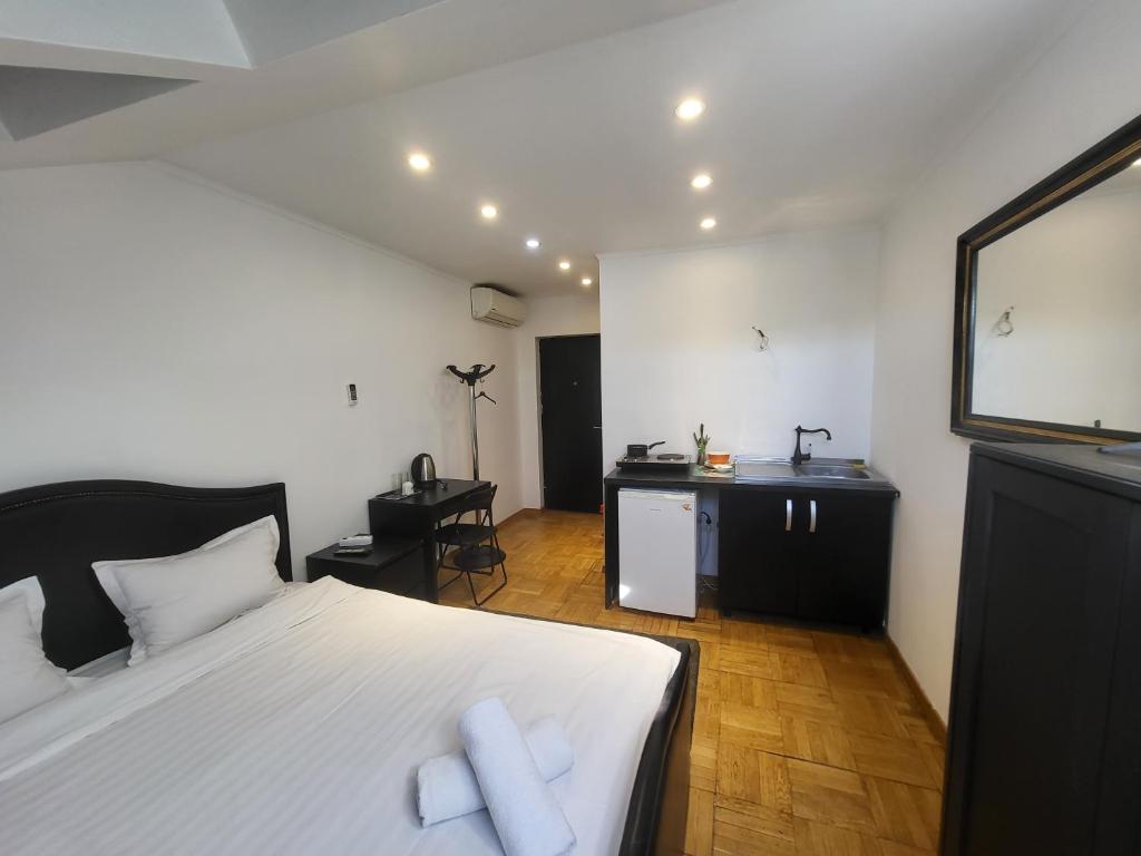 1 dormitorio con 1 cama blanca grande y escritorio en Studio Buget Arena Nationala Mega Mall Monza, en Bucarest