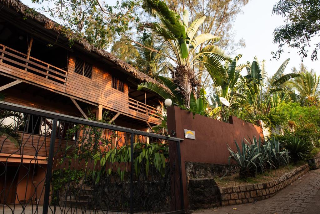 a building with a fence and some plants at Banana Moon in Ambatoloaka