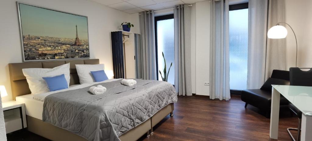 ein Hotelzimmer mit einem Bett, einem Stuhl und Fenstern in der Unterkunft City NOWA in Nürnberg
