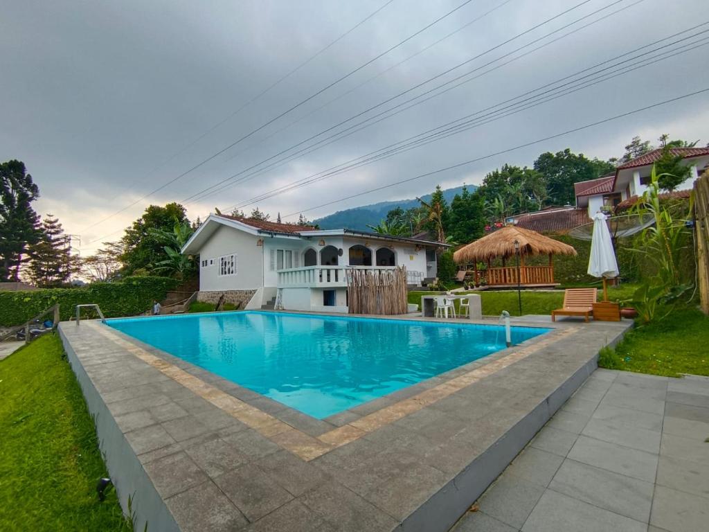 a swimming pool in the backyard of a house at Villa Cisarua Wulan in Brujul