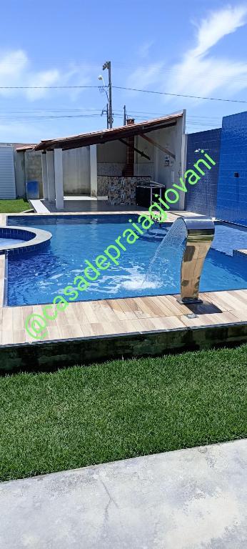 a swimming pool with a ramp in front of a building at Casa de praia giovani in Aracaju