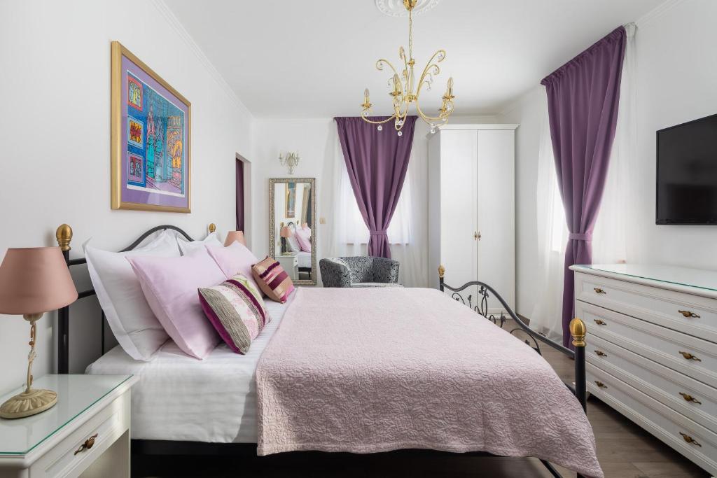 a bedroom with a bed with purple curtains at Romantic Luxury Rooms in Split