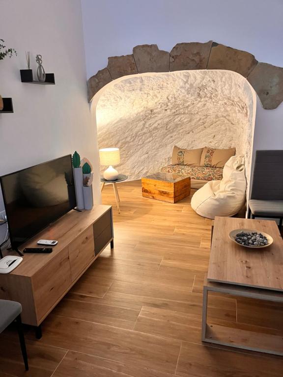sala de estar con sofá y TV en Apartamentos El PELIGRO 3 LA CUEVA en Archidona